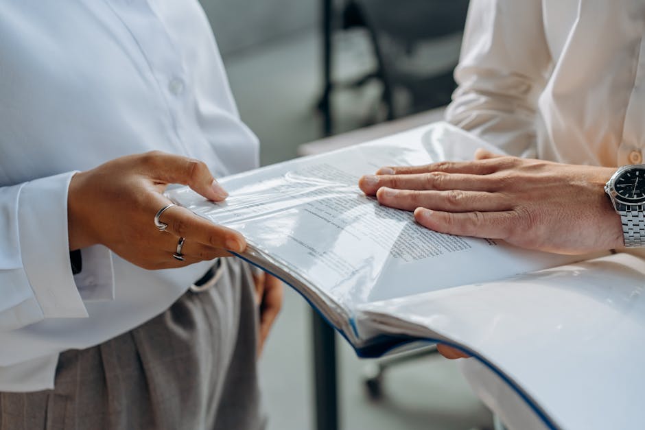 Two professionals examining business documents during a meeting indoors
