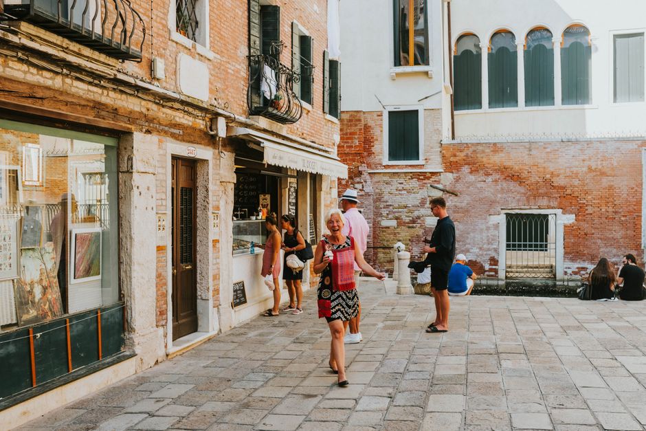 Sretni turisti istražuju šarmantne uličice Venecije na sunčan dan.